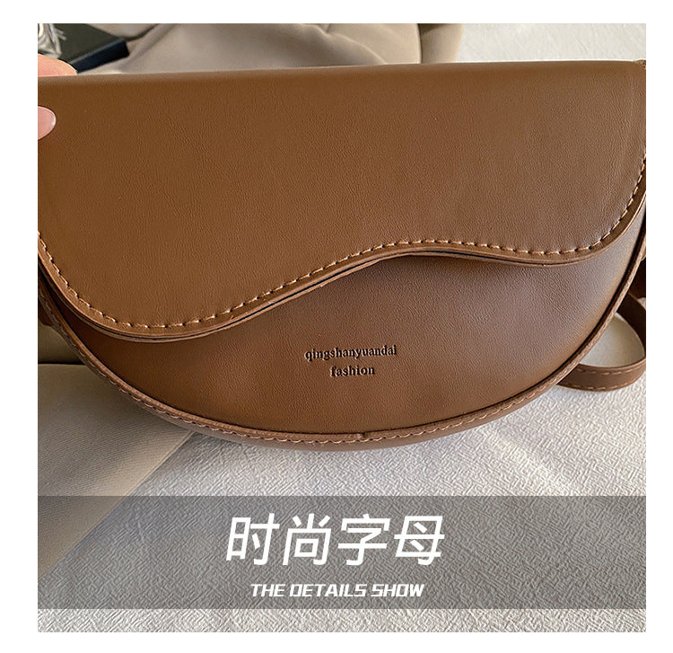 The Wave Silhouette Asymmetric Leather Saddle Bag